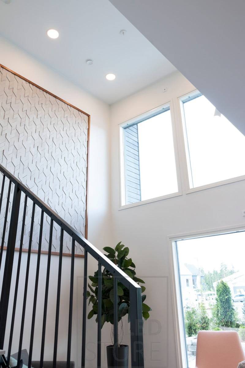 Dans le haut plafond, les plafonniers créent un éclairage général et illuminent l'escalier.